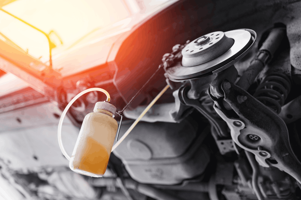 Brake fluid flush, auto repair in Bend, OR by Mountain View Imports. Image of brake caliper and rotor with a brake fluid bleeding bottle attached, highlighting professional brake system maintenance to ensure safe stopping power and optimal vehicle performance.