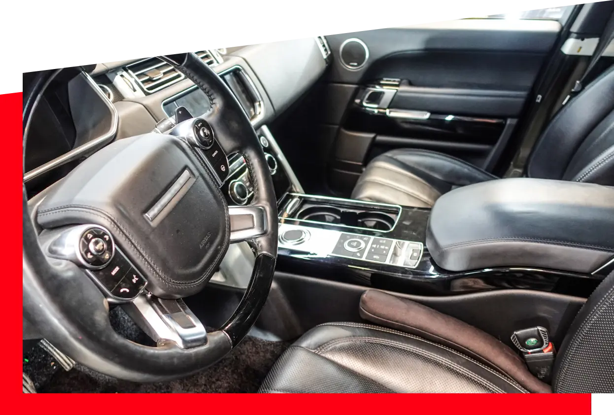 Interior view of a car featuring luxurious leather seats and a sleek steering wheel.