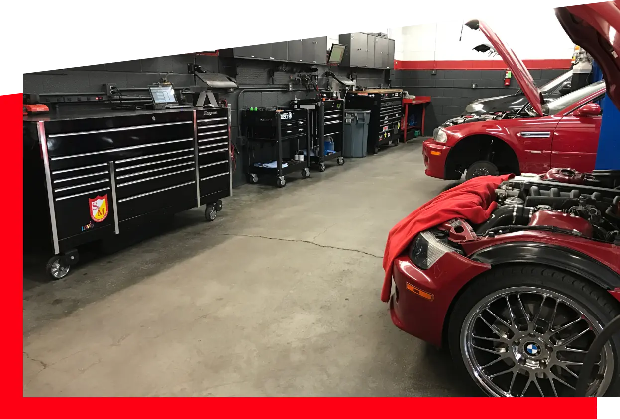 Cars parked inside the auto repair garage surrounded by equipment