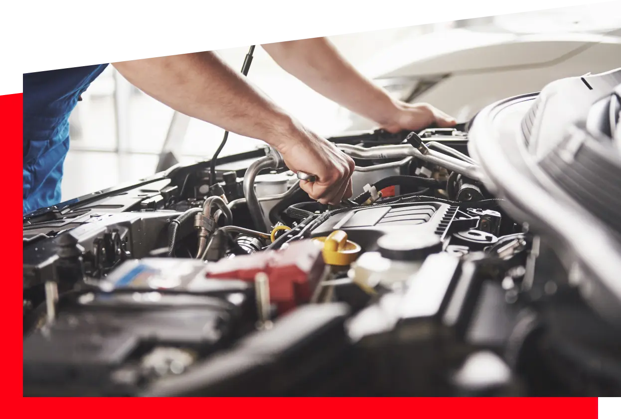 A person works intently on a car engine, demonstrating expertise in vehicle repair and maintenance.